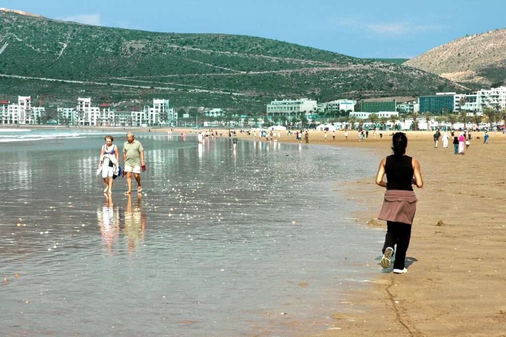 People enjoying a sunny day at a beautiful beach in Agadir, Morocco.