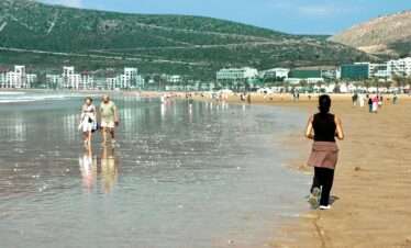 People enjoying a sunny day at a beautiful beach in Agadir, Morocco.