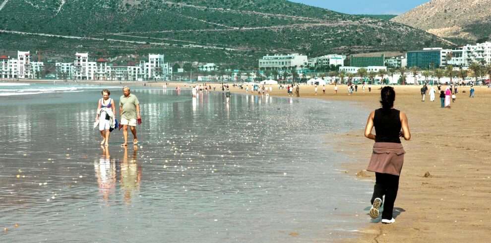 People enjoying a sunny day at a beautiful beach in Agadir, Morocco.