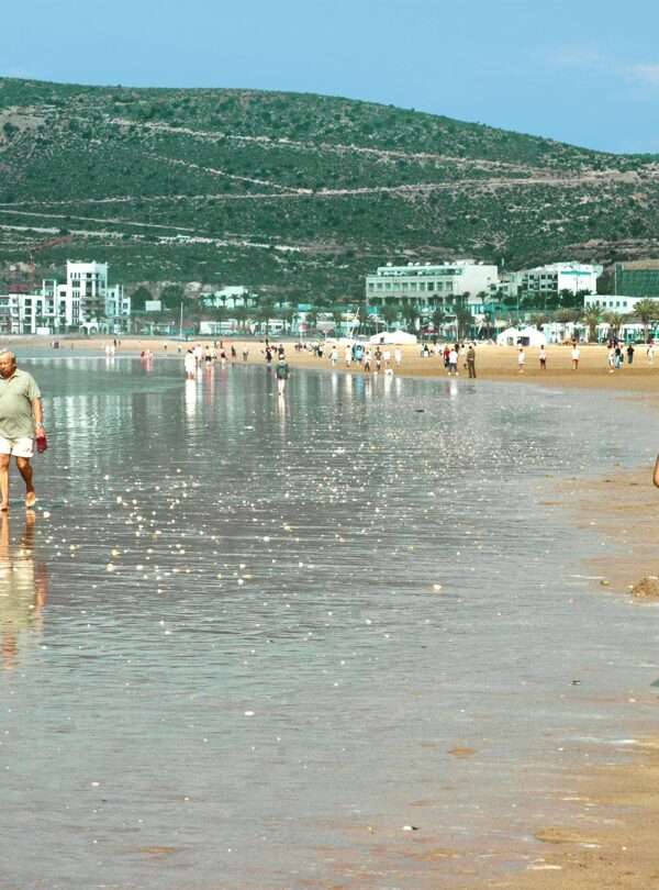 People enjoying a sunny day at a beautiful beach in Agadir, Morocco.